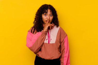 Pembe arka planda soyutlanmış genç melez bir kadın ya sır saklıyor ya da sessizlik istiyor..