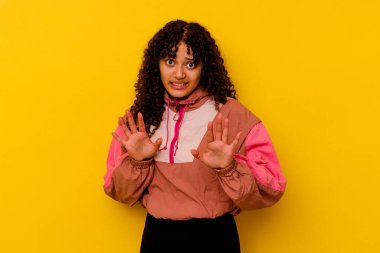 Pembe arka planda izole edilmiş genç bir ırk kadını, tiksinti gösteren birini reddediyor..