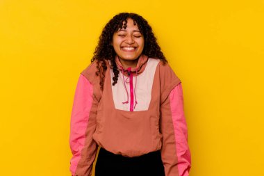 Pembe arka planda soyutlanmış genç melez kadın gülüyor ve gözlerini kapıyor, rahatlamış ve mutlu hissediyor..