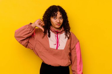 Pembe arka planda izole edilmiş genç melez bir kadın. Hoşnutsuz bir jest gösteriyor. Anlaşmazlık konsepti.