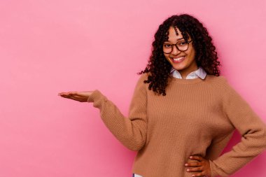 Pembe arka planda izole edilmiş genç bir ırk kadını bir avuç içinde fotokopi alanı ve belinde başka bir el tutarken görülüyor..