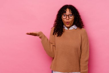 Pembe arka planda izole edilmiş genç melez bir kadın..