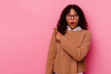 Pembe arka planda soyutlanmış genç melez bir kadın.