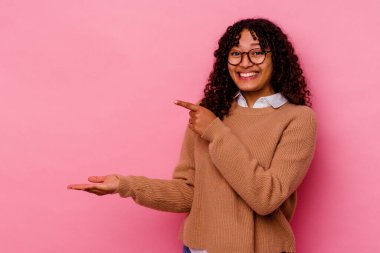 Pembe arka planda izole edilmiş genç melez bir kadın..