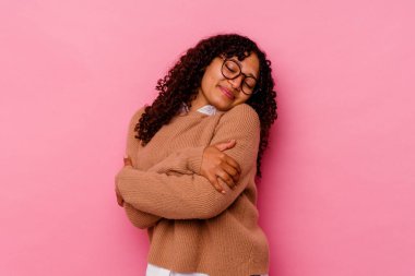 Genç melez kadın pembe arka planda izole edilmiş, gülümseyen, kaygısız ve mutlu..