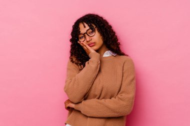 Pembe arka planda soyutlanmış, sıkılmış, yorgun ve dinlenmeye ihtiyacı olan genç melez bir kadın..