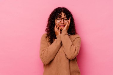 Genç melez kadın, pembe arka planda izole edilmiş sızlanıyor ve ağlıyordu..