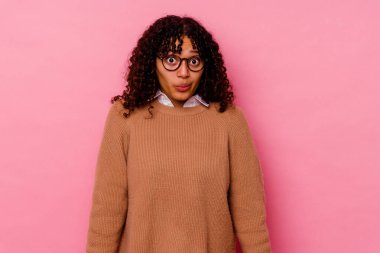 Pembe arka planda soyutlanmış genç bir ırk kadını omuzlarını silker ve gözleri açık kalır..