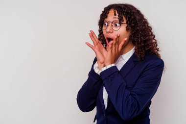 Beyaz arka planda izole edilmiş genç iş kadını yüksek sesle bağırıyor, gözleri açık ve elleri gergin tutuyor..