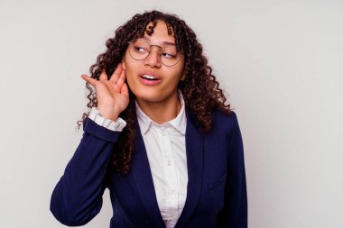 Genç bir iş kadını beyaz arka planda izole edilmiş bir şekilde bir dedikoduyu dinlemeye çalışıyor..