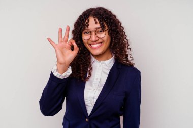 Genç iş kadını, beyaz arka planda izole edilmiş neşeli ve kendinden emin, iyi bir jest yapıyor..