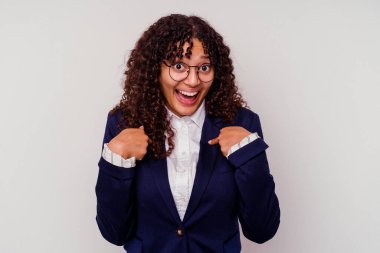 Beyaz arka planda izole edilmiş genç iş kadını parmağını gösterip geniş bir gülümsemeyle şaşırdı..