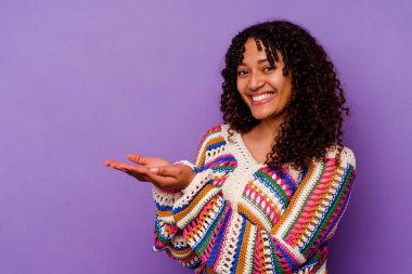 Mor arka planda izole edilmiş genç melez bir kadın avucunun içinde bir kopyasını tutuyor..