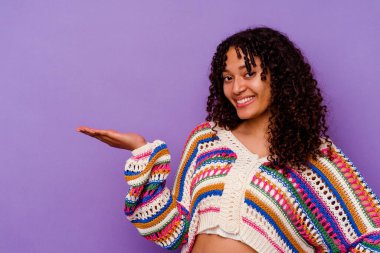 Mor arka planda izole edilmiş genç bir ırk kadını bir avuç içinde fotokopi alanı ve belinde başka bir el tutarken görülüyor..