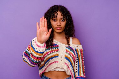 Mor arka planda izole edilmiş genç bir ırk kadını elini uzatmış, dur işareti göstererek seni engelliyor..