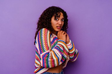 Mor arka planda yalnız, korkmuş ve korkmuş genç bir ırk kadını..