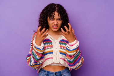 Mor arka planda izole edilmiş genç melez kadın gergin ellerle çığlık atıyor..