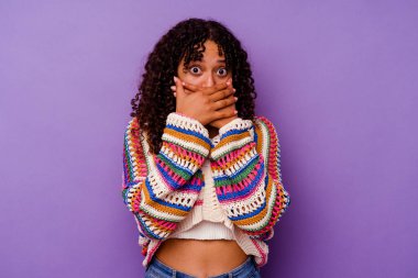 Mor arka planda izole edilmiş genç bir ırk kadını elleriyle ağzını kapatırken şok oldu..