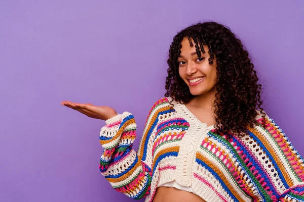 Mor arka planda izole edilmiş genç bir ırk kadını bir avuç içinde fotokopi alanı ve belinde başka bir el tutarken görülüyor..