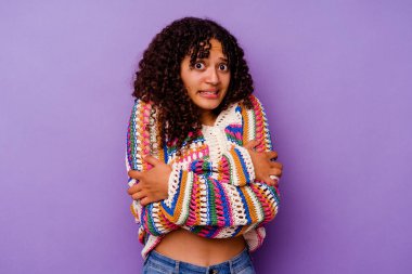 Mor arka planda izole edilmiş genç melez kadın düşük ateş ya da hastalık yüzünden soğuyor..