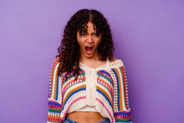 Mor arka planda izole edilmiş genç bir ırk kadını çok sinirli ve agresif bağırıyor..