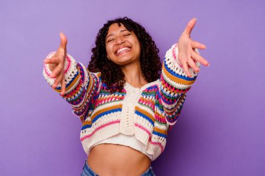 Mor arka planda izole edilmiş genç melez kadın kameraya sarıldığı için kendinden emin..