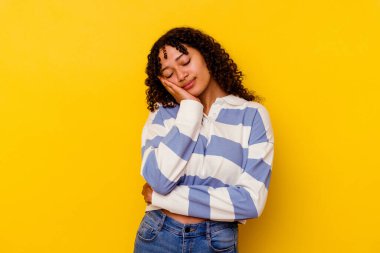 Sarı arka planda soyutlanmış, sıkılmış, yorgun ve dinlenmeye ihtiyacı olan genç melez bir kadın..