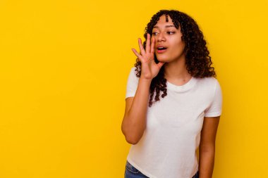 Sarı arka planda soyutlanmış genç melez bir kadın gizli bir fren haberinin olduğunu söylüyor.