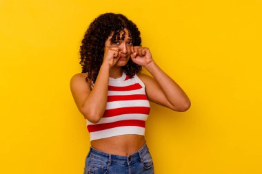 Genç melez kadın sarı arka planda izole edilmiş sızlanıyor ve ağlıyordu..