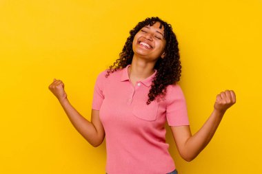 Sarı arka planda izole edilmiş genç bir ırk kadını rahat ve mutlu bir gülüş, boynunda dişlerini gösteren bir gerdanlık..