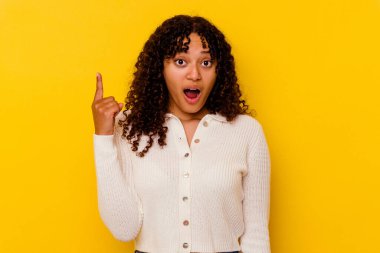 Sarı arka planda izole edilmiş genç melez kadının bir fikri, ilham konsepti var..