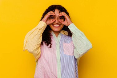 Sarı arka planda izole edilmiş genç melez kadın gözlerde sorun olmadığını gösteriyor.