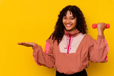 Sarı arka planda soyutlanmış genç, melez bir kadın.