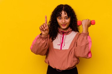 Sarı arka planda soyutlanmış genç, melez bir kadın.