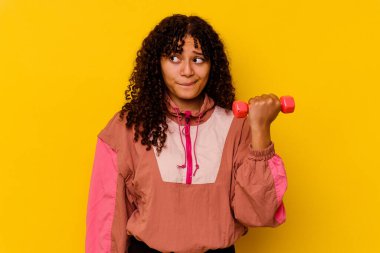 Sarı arka planda soyutlanmış genç, melez bir kadın.