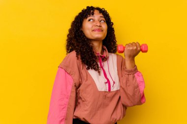 Sarı arka planda soyutlanmış genç, melez bir kadın.