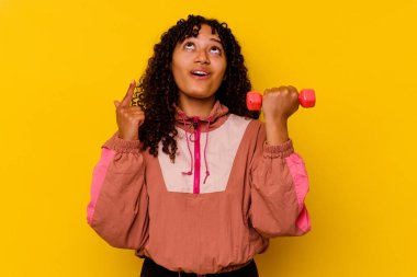 Sarı arka planda soyutlanmış genç, melez bir kadın.