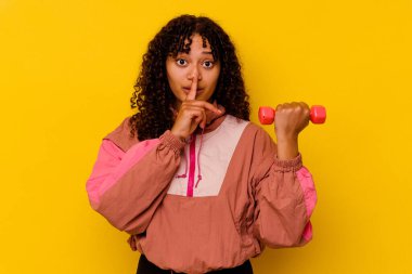 Sarı arka planda soyutlanmış genç, melez bir kadın.