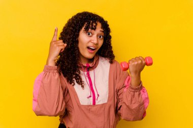 Sarı arka planda soyutlanmış genç, melez bir kadın.