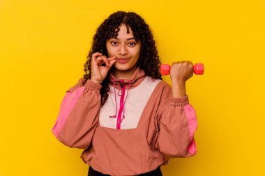 Sarı arka planda soyutlanmış genç, melez bir kadın.