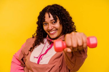 Sarı arka planda soyutlanmış genç, melez bir kadın.