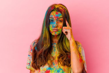 Kutsal bayramı kutlayan genç Hintli kadın beyaz arka planda izole edilmiş bir şekilde tapınağı işaret ediyor, düşünüyor ve bir göreve odaklanıyor..