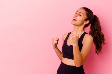 Pembe arka planda izole edilmiş genç Hintli kadın zaferden sonra yumruğunu kaldırıyor, kazanan konsept..