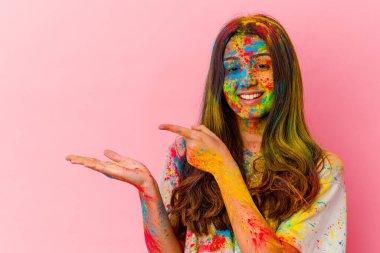 Kutsal bayramı kutlayan genç Hintli kadın beyaz arka planda izole edilmiş, elinde bir fotokopi odası tutarken heyecanlı..