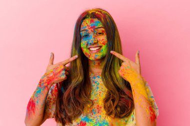 Kutsal bayramı kutlayan genç Hintli kadın beyaz arka planda izole edilmiş gülücükler içinde, parmaklarını ağıza doğrultarak.