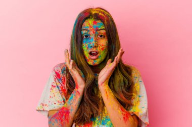 Kutsal festivali kutlayan genç Hintli kadın beyaz arka planda izole edilmiş şaşırmış ve şok olmuş..