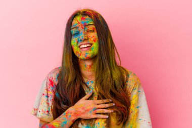 Beyaz arka planda izole edilmiş kutsal festivali kutlayan genç Hintli kadın elini göğsüne koyarak kahkahalar atıyor..