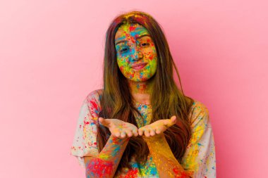 Genç Hintli kadın kutsal festivali kutluyor. Beyaz arka planda izole edilmiş. Elinde avuç içi olan bir şeyle kameraya sunuyor..