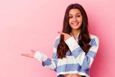 Pembe arka planda izole edilmiş genç Hintli bir kadın. Elinde bir fotokopi odası tutarken heyecanlı..