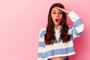 Pembe arka planda izole edilmiş genç Hintli kadın yüksek sesle bağırıyor, gözlerini açık ve ellerini gergin tutuyor..